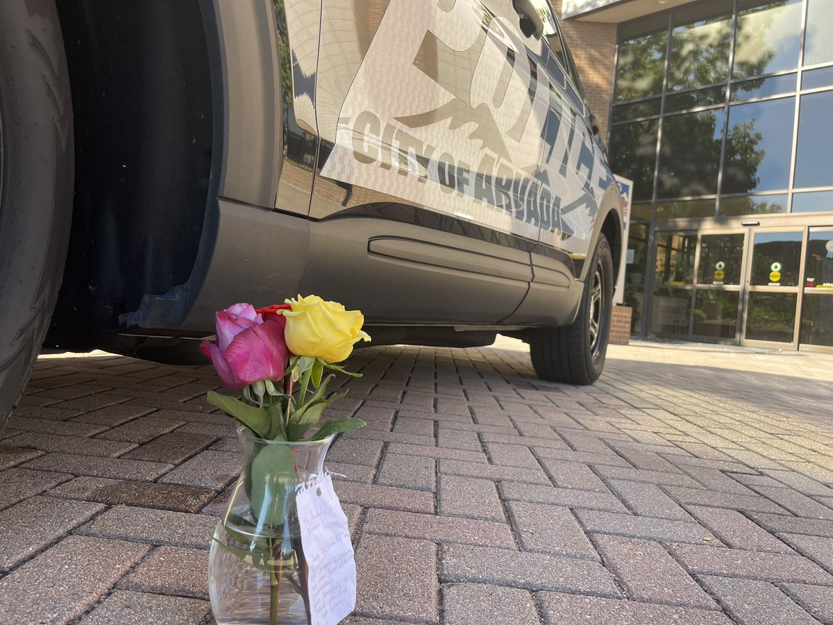 An Arvada officer was killed while responding to a disturbance. A suspect is in custody.   Flowers sit on an Arvada cruiser outside the police station